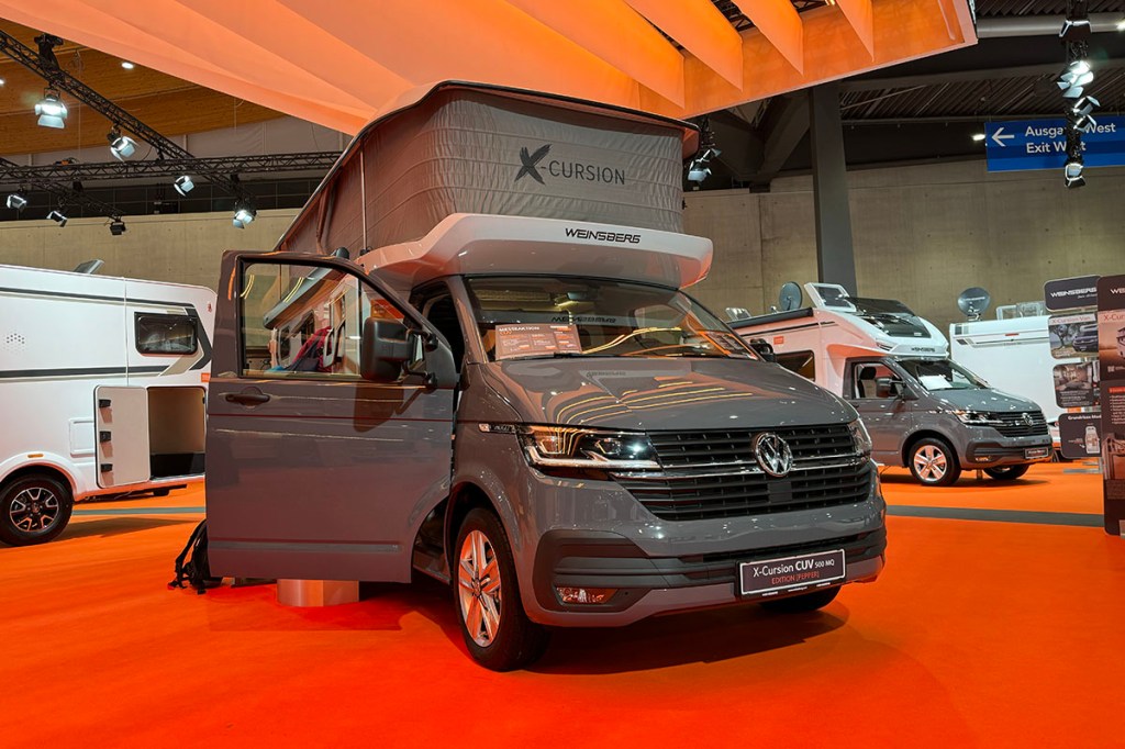 Camper Van X-Cursion von Weinsberg auf Messestand mit ausgefahrenen Hochdach.