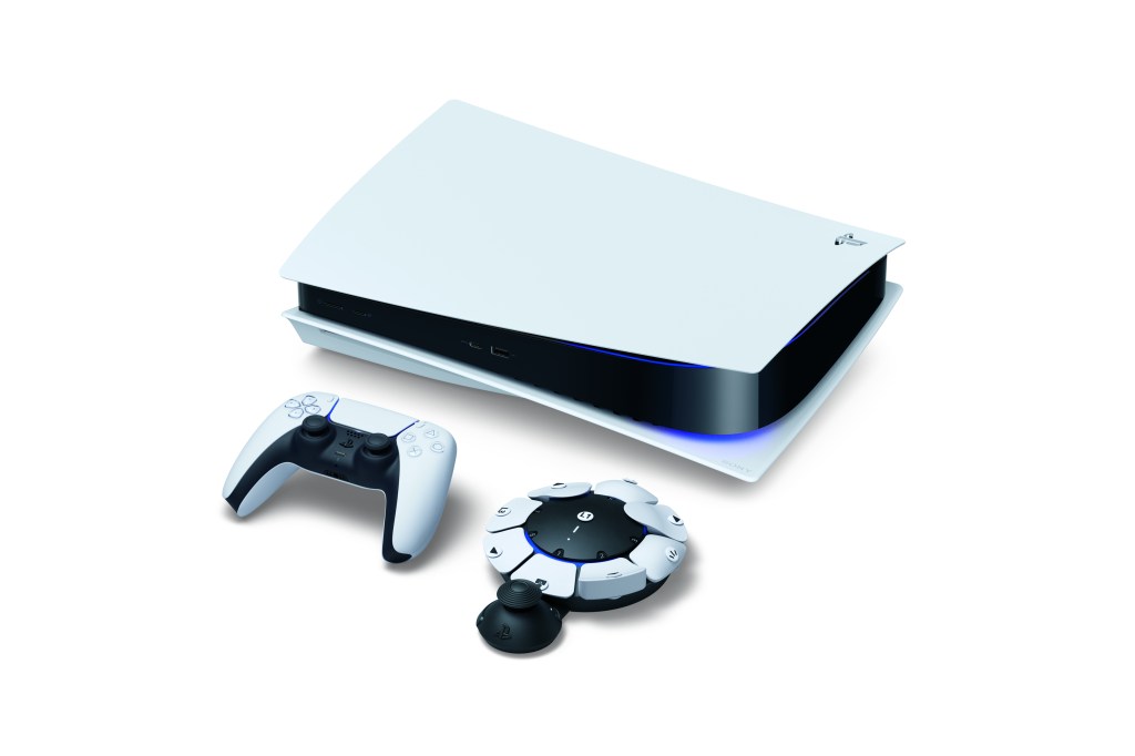 PlayStation5, DualSense Edge und Access Controller liegen nebeneinander auf weißer Fläche.
