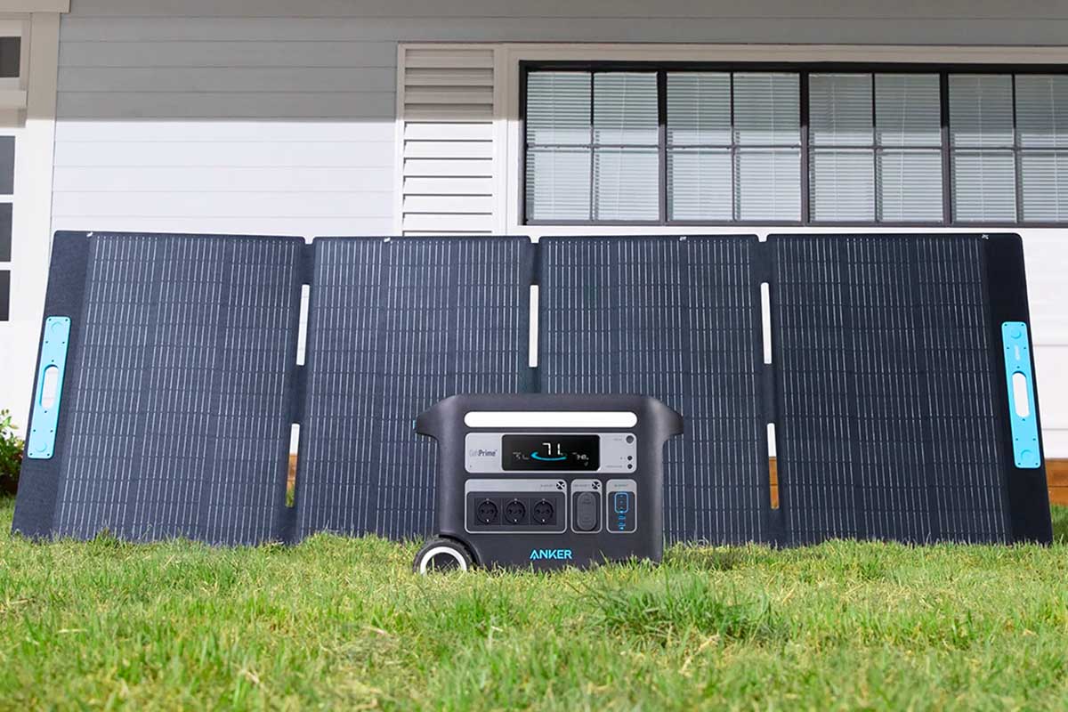 Eine Anker Powerstation und das neue Solix PS400 Solarpanel in einem Garten.