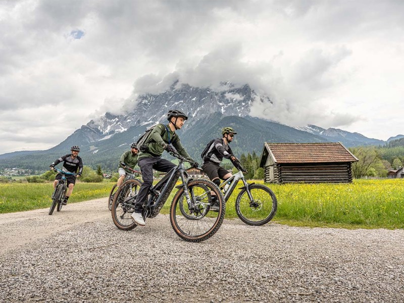 Mehrere Fahrradfahrer fahren mit Mountainbikes durch eine Bergregion