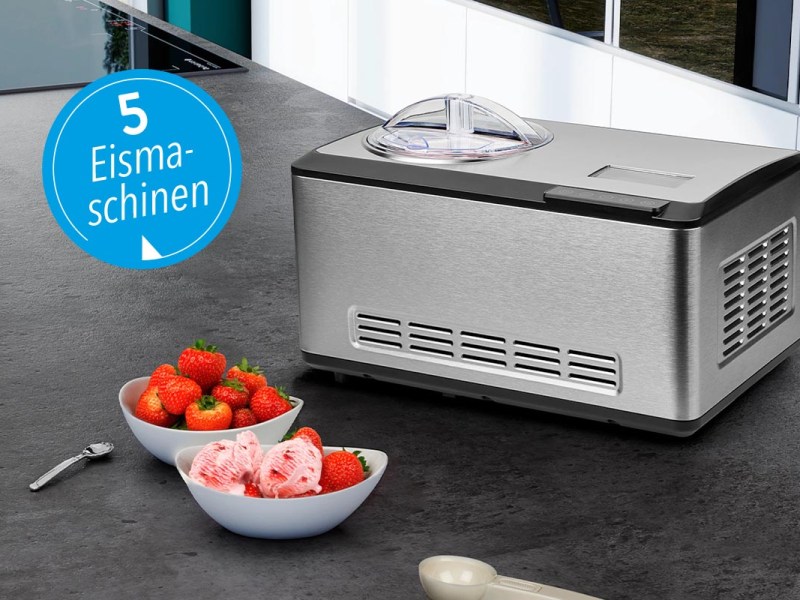 Eine Eismaschine von Medion neben Schalen mit Erdbeeren auf einer Küchentheke.