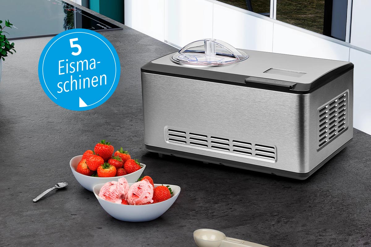 Eine Eismaschine von Medion neben Schalen mit Erdbeeren auf einer Küchentheke.