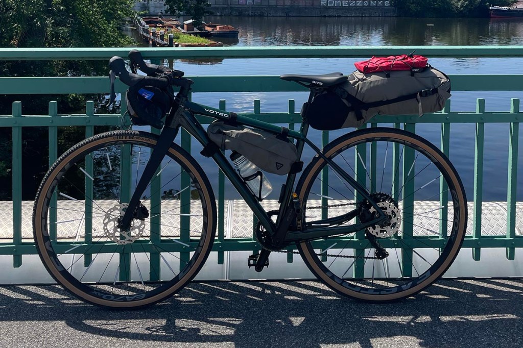 Fahrrad mit Fahrradtaschen an ein Brückengeländer gelehnt