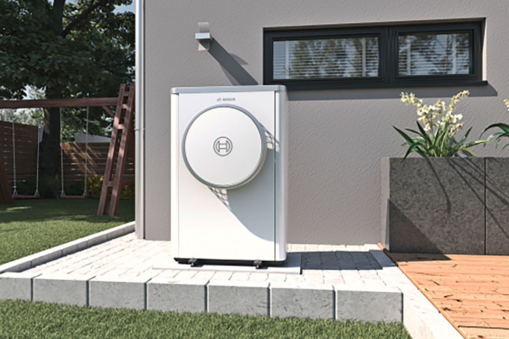 Die Compress 7400i AW-Wärmepumpe von Bosch Thermotechnik auf einer Terrasse vor einem Haus.