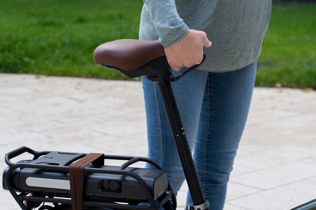 Nahaufnahme, Hand greift unter den Sattel eines Fahrrads