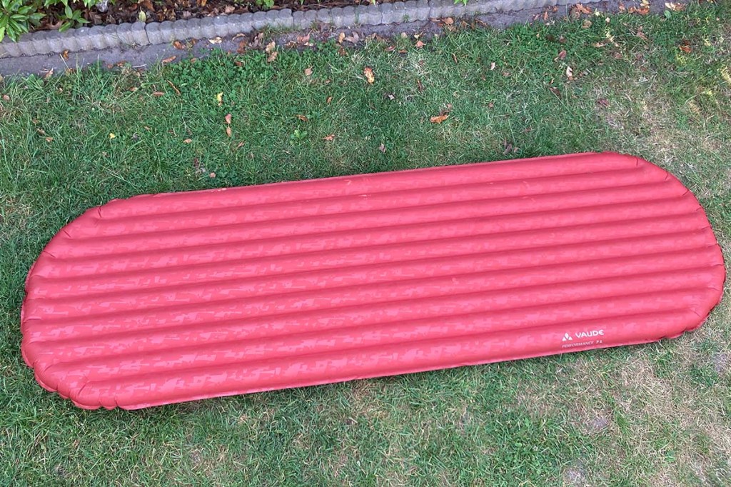 rote Isomatte auf einer wiese liegend