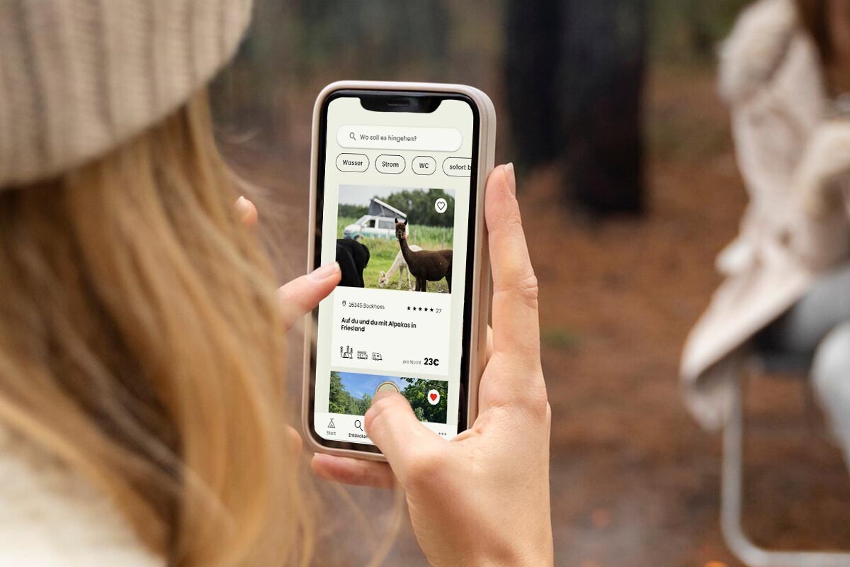 Overshoulder-Blick auf ein Smartphone, man sieht, wie die Person nach Campingplätzen sucht