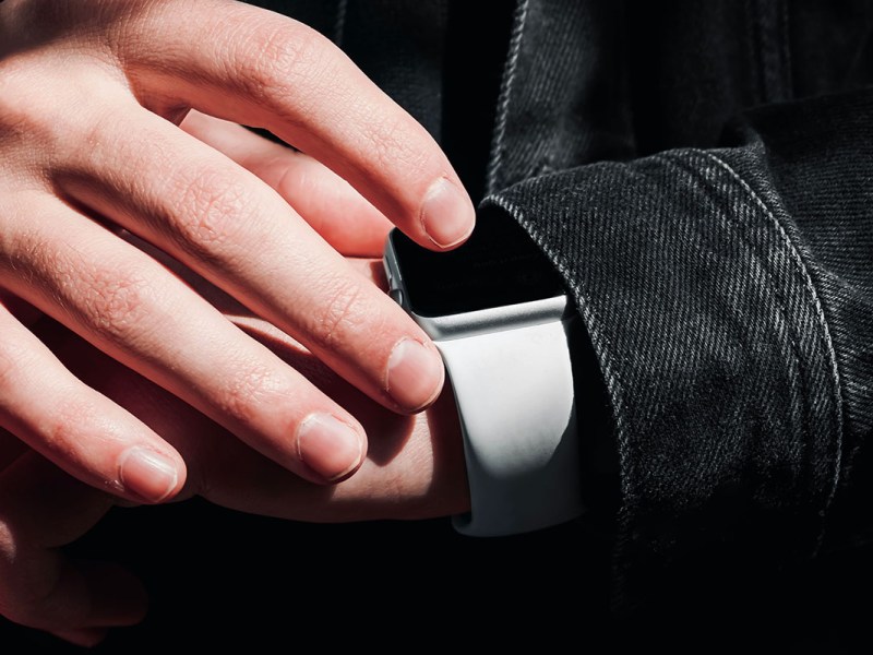 Eine Hand bedient eine Smartwatch am Handgelenk.