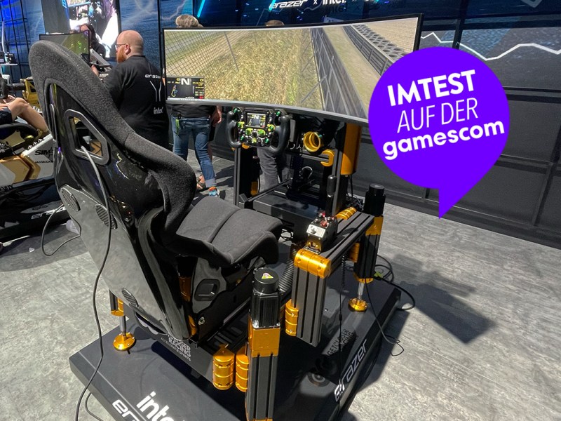 Ein SimRacing-Rig von GetCloserRacing auf dem Messestand der gamescom 2023. Ein Rennsitz, Pedale und Lenkrad sind erkennbar. Darüber ein großer Bildschirm.