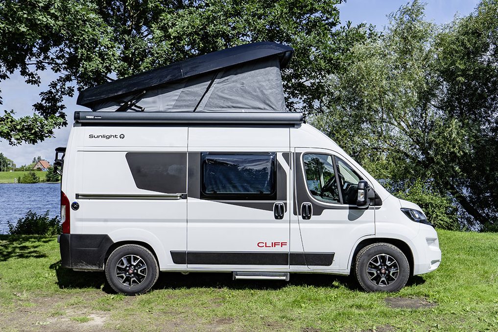 Der Camper Van Sunlight Cliff 540 RT Adventeure Edition in seitlicher Ansicht auf einem Campingplatz.