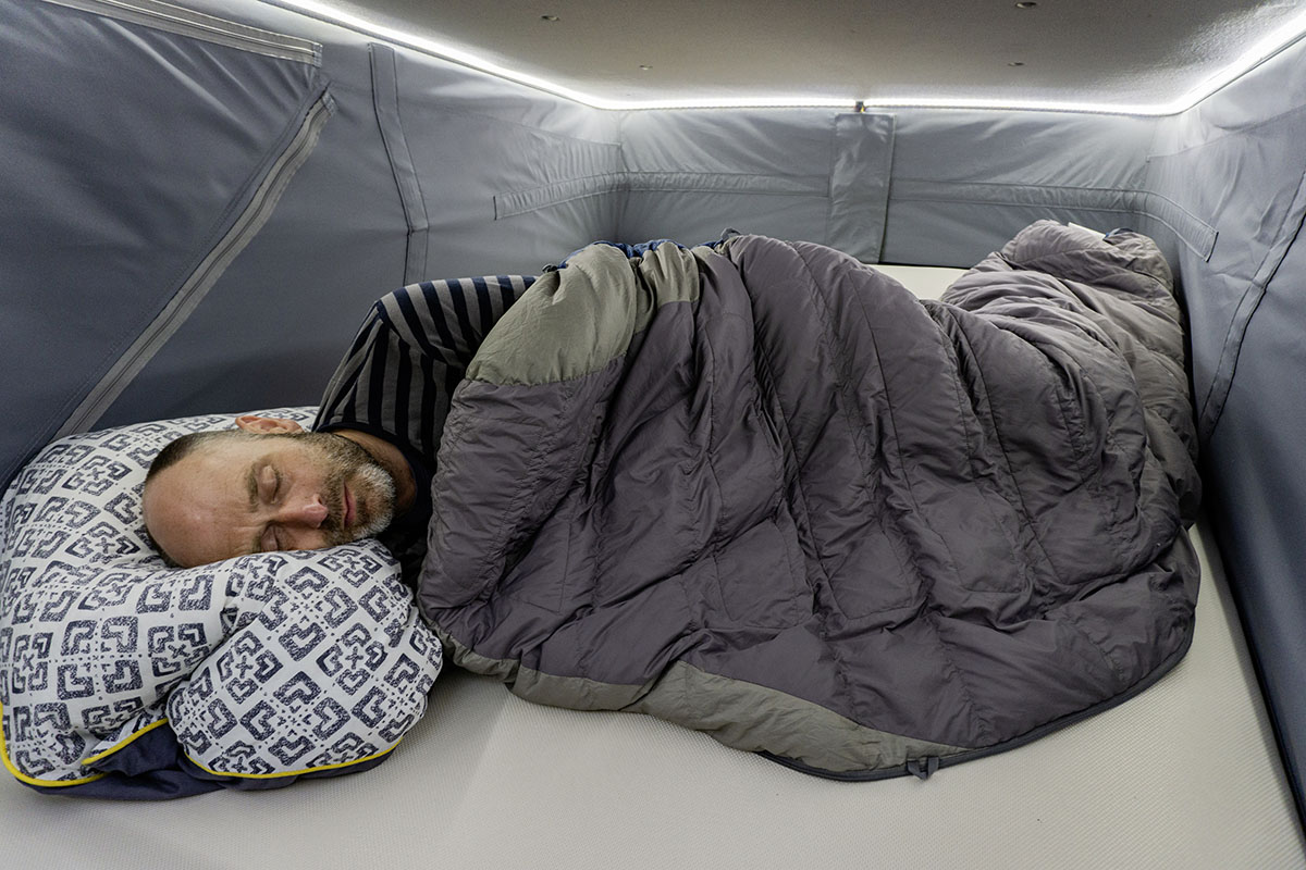 Mann schläft im Camper-Van