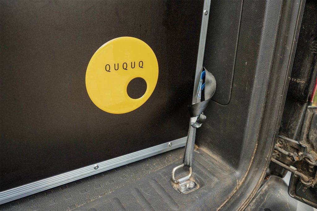 Ein Spanngurt hält die QUQUQ-Box im Auto.