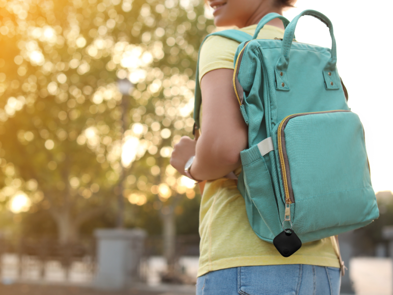 Smart Tag von Maginon am Rucksack einer Frau befestigt