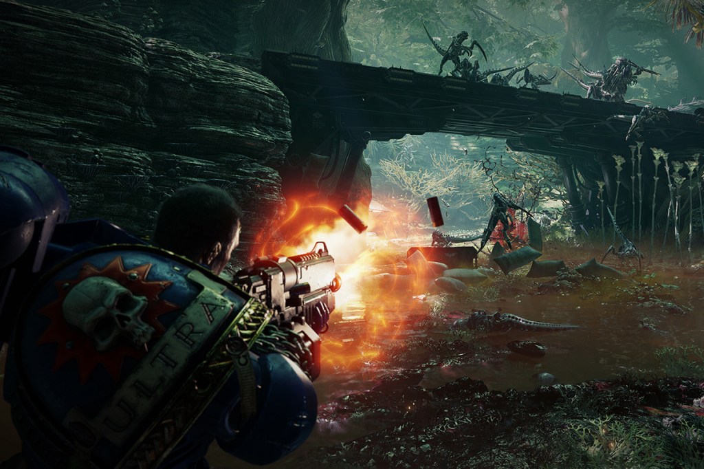 Screenshot des Action-Spiels Space Marine 2. Im Vordergrund feuert die Spielfigur ihre Waffe ab, hinten Aliens auf einer Brücke im Dschungel.