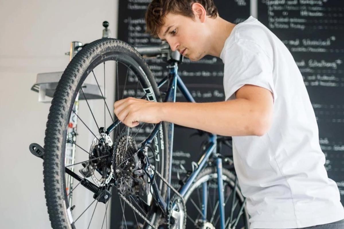 Person schraubt an einem Fahrrad.