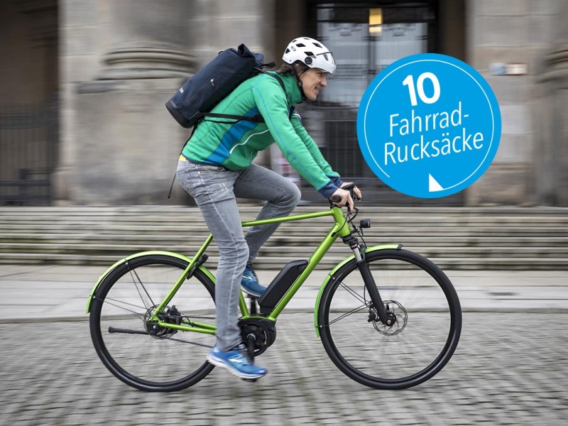 Mann auf einem Fahrrad mit Rucksack auf dem Rücken.