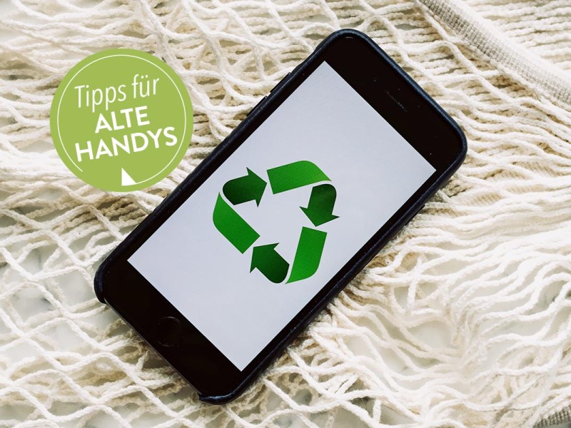 Smartphone auf hellen Stofffäden liegend.