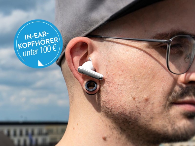 Mann mit In-Ear-Kopfhörer von Anker unter freiem Himmel.