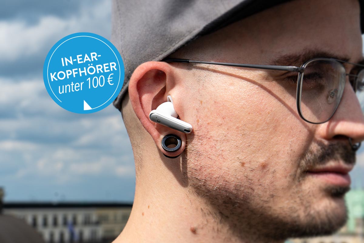 Mann mit In-Ear-Kopfhörer von Anker unter freiem Himmel.