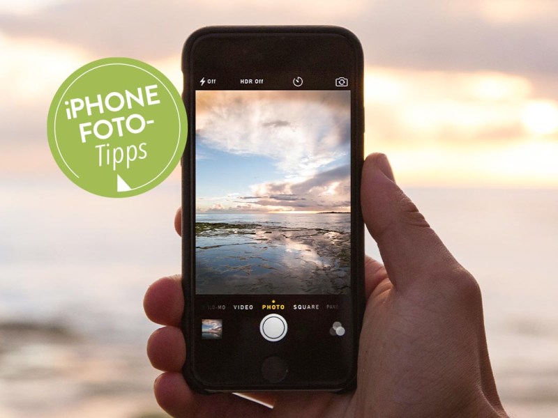 In der Hand gehaltenes iPhone, mit dem ein Foto vom Meer geschossen wird.