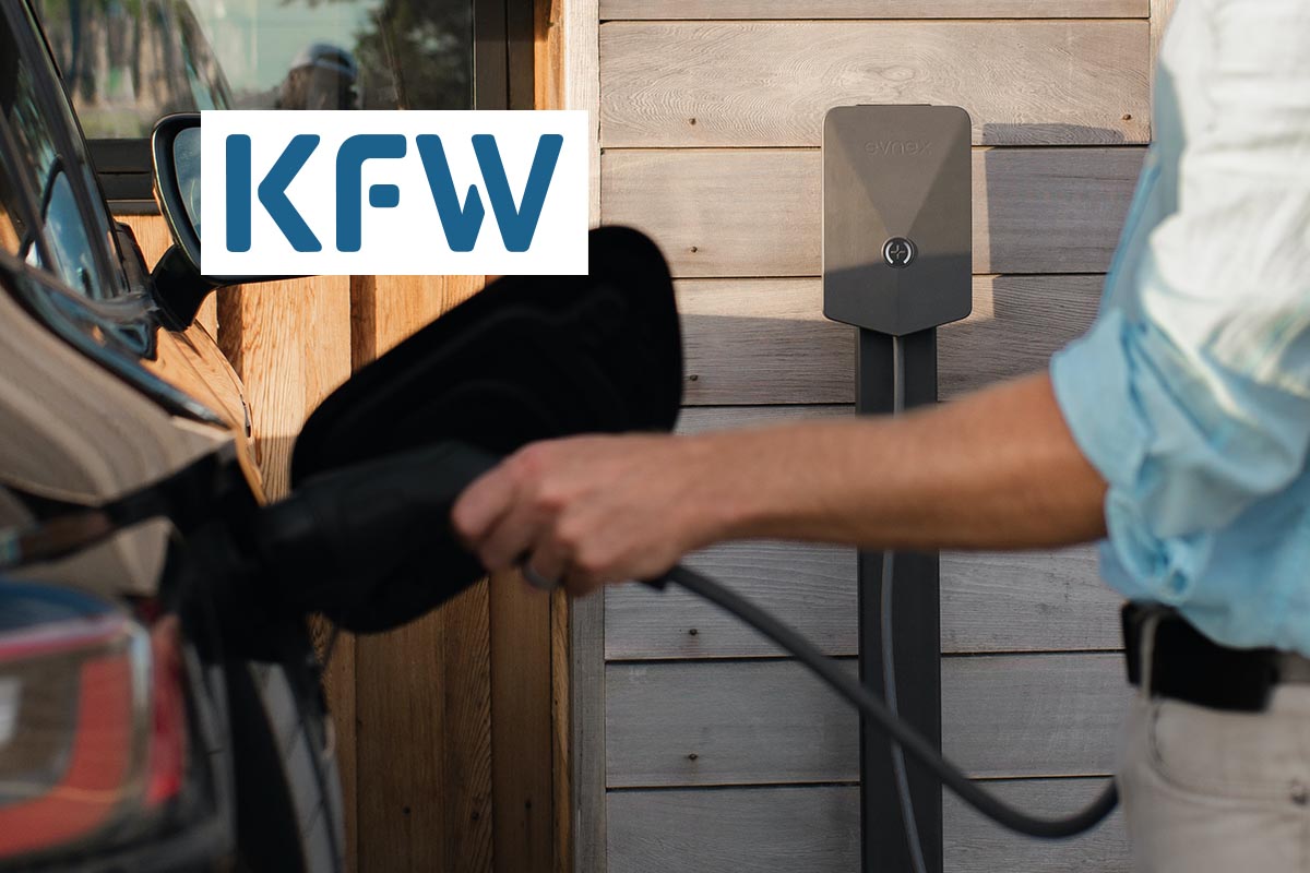 Eine Person lädt ihr Elektroauto auf. In der oberen Ecke des Bildes ist das Logo der KfW.