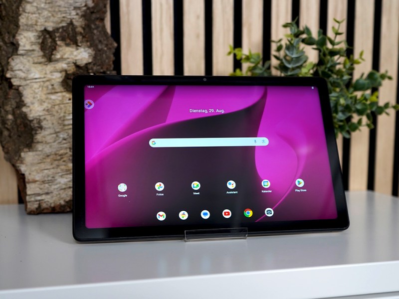 Das eingeschaltete Telekom T Tablet steht auf einbem Sideboard.