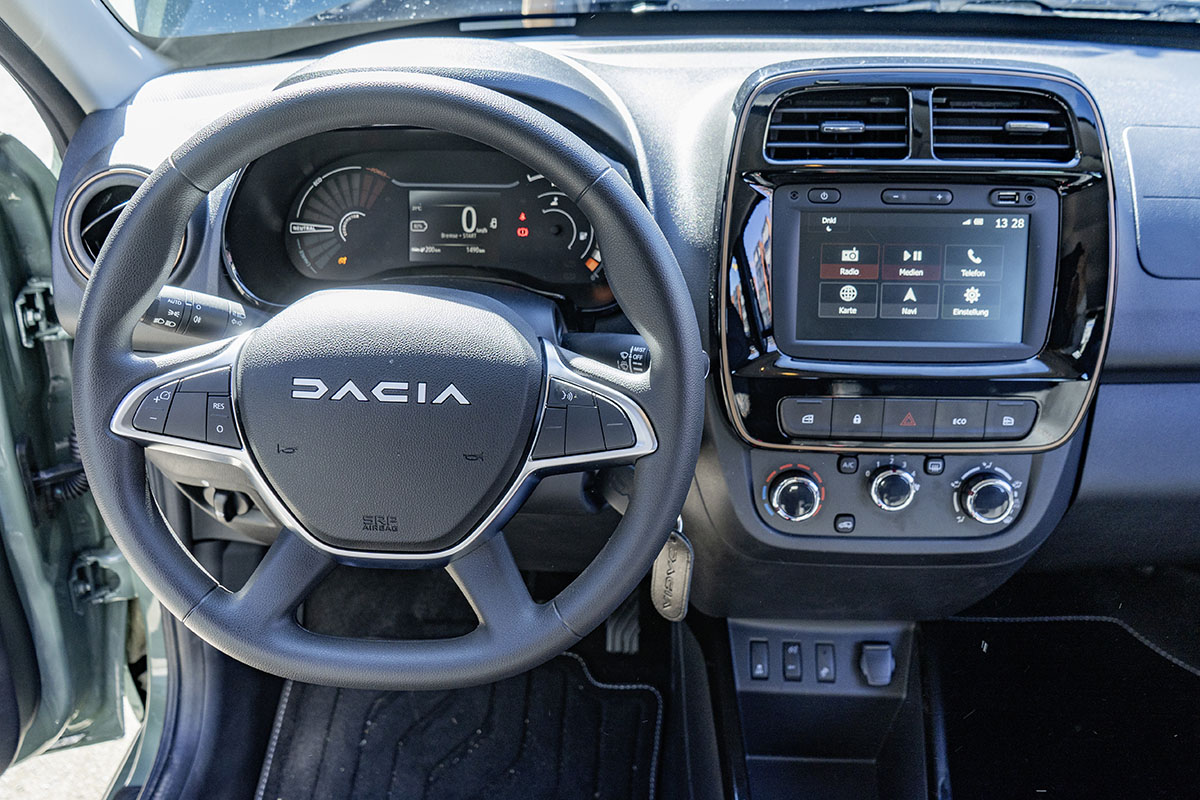Innenaufnahme E-Auto: Blick auf Lenkrad und Infotainment-Display beim Dacia Spring Extreme 65.