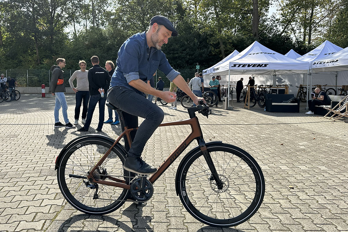 Mann auf einem City-E-Bike vor einem Veranstaltungszelt.