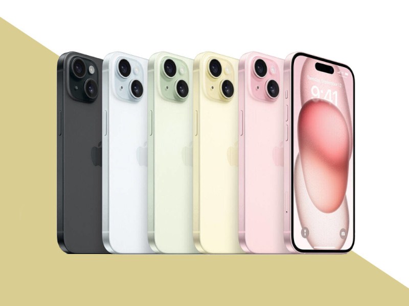 Fünf iPhone 15 seitlich in Reihe aufgestellt von hinten in verschiedenen Farben, links das Pinke zusätzlich von vorne mit rosa Bildschirm auf gold weißem Hintergrund