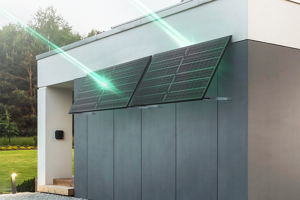 Zwei Solarpanels mit Halterung an einer Hauswand. Grüne Strahlen symbolisieren die Sonnenstrahlen.
