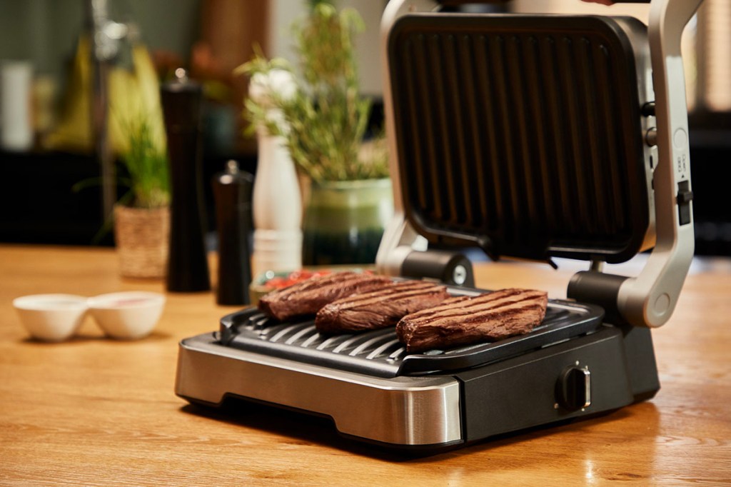 Der OptiGrill 4in1 von Tefal mit gegrillten Steaks.