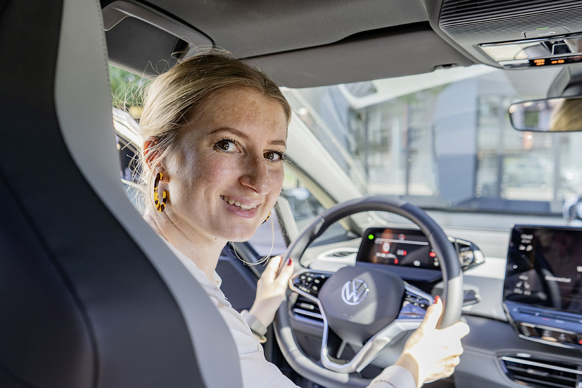 VW ID.3 Pro: Autofahrerin, die am Lenkrad sitzt mit Schulterblick in den hinteren Bereich des Autos.