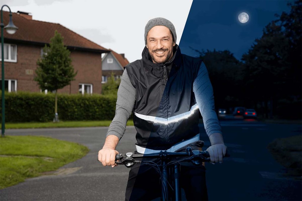 Mann fährt mit einem Fahrrad, trägt eine LED-Weste