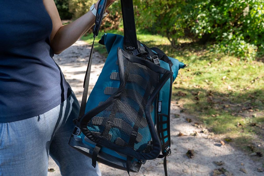 Frau im Anschnitt, hält Rucksack in der Händen