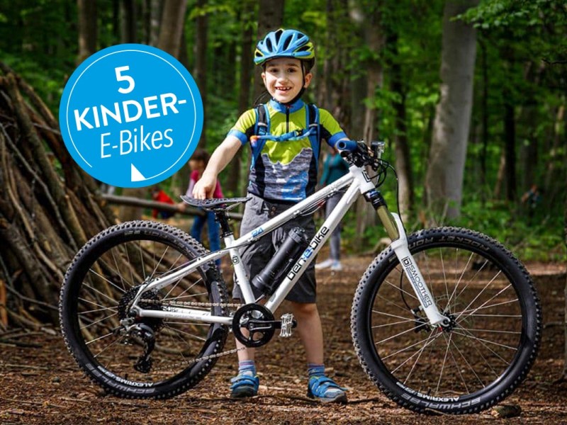 Kind vor einem E-Bike stehend in einem Wald.