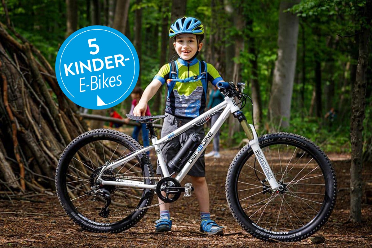 Kind vor einem E-Bike stehend in einem Wald.