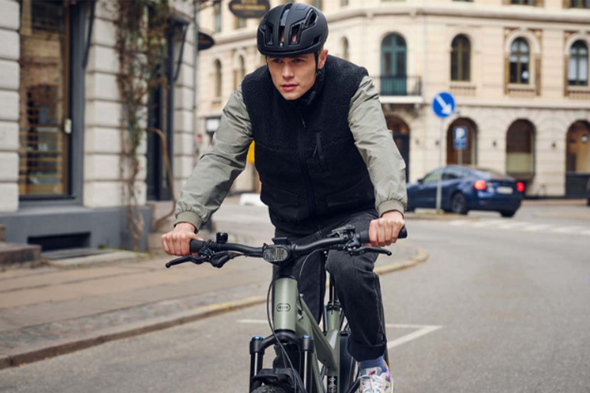 Mann fährt mit einem E-bike durch eine Stadt