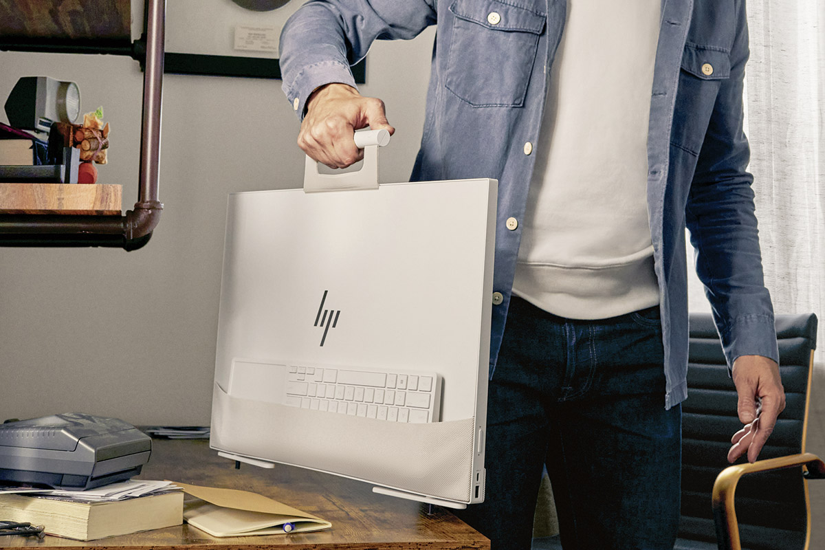Der neue All-in-one PC HP Envy Move wird an seinem Henkel durch die Wohnung getragen.