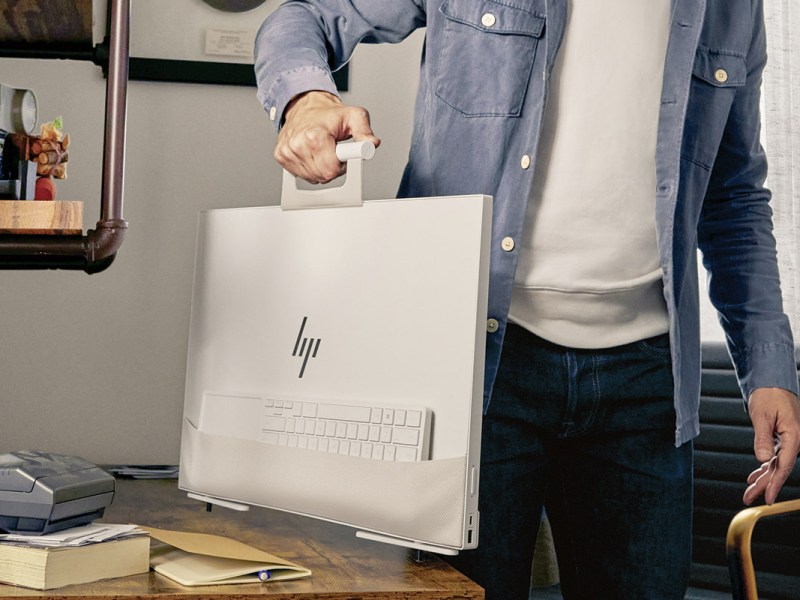 Der neue All-in-one PC HP Envy Move wird an seinem Henkel durch die Wohnung getragen.