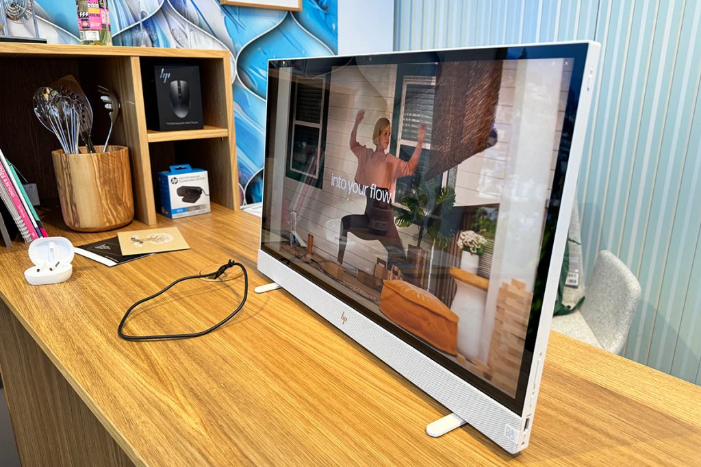 Der All-in-one-Computers HP Envy Home steht auf einem braunen Holztisch.