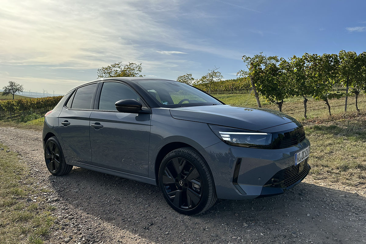 Opel Corsa Electric vor einem Weinberg.