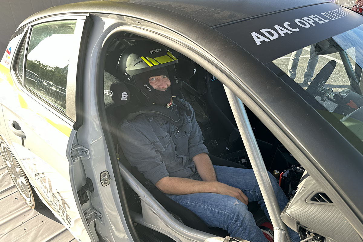 Mann mit Helm auf Beifahrersitz in einem Rallye-Auto.
