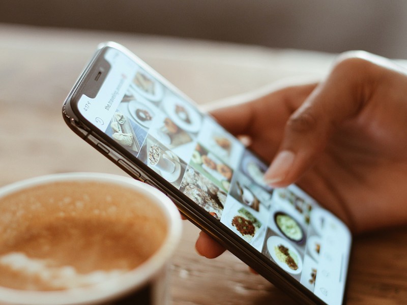 Ein Handy mit Instagram neben einer Tasse.
