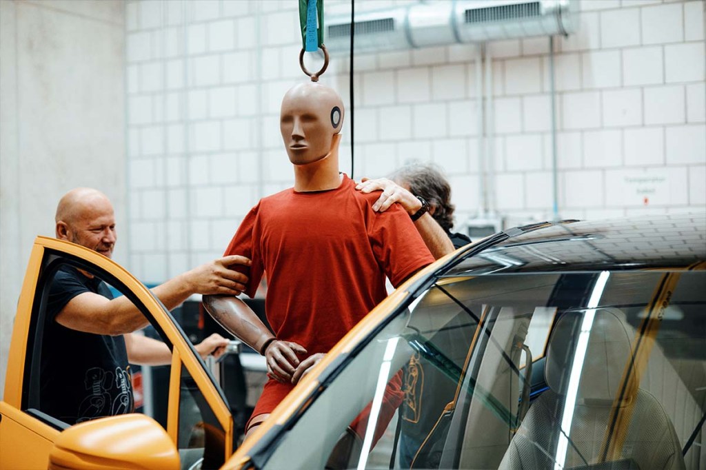 Ein Dummy neben einem Auto im Rahmen eines Crashtests