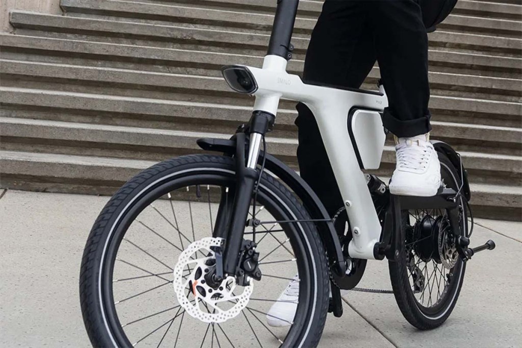 Anschnitt, Person auf einem E-bike seitlich von vorne, man sieht nur die Beine