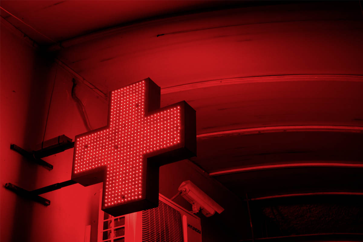 Ein leuchtendes Schild, dass einen rotes Kreuz als Rettungsdienst-Zeichen zeigt