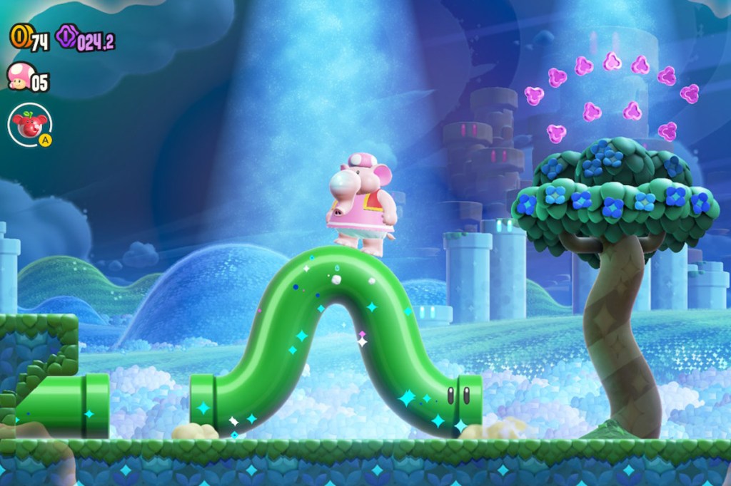 Screenshot aus dem Spiel Super Mario Bros. Wonder. Man sieht einen Elefant, der auf einer grünen, sich biegenden Röhre reitet.