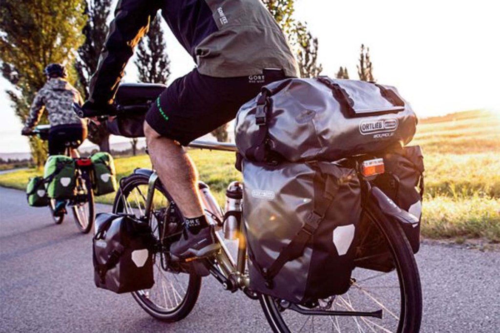 Fahrradfahrer von hinten, ist mit vielen Gepäcktaschen beladen