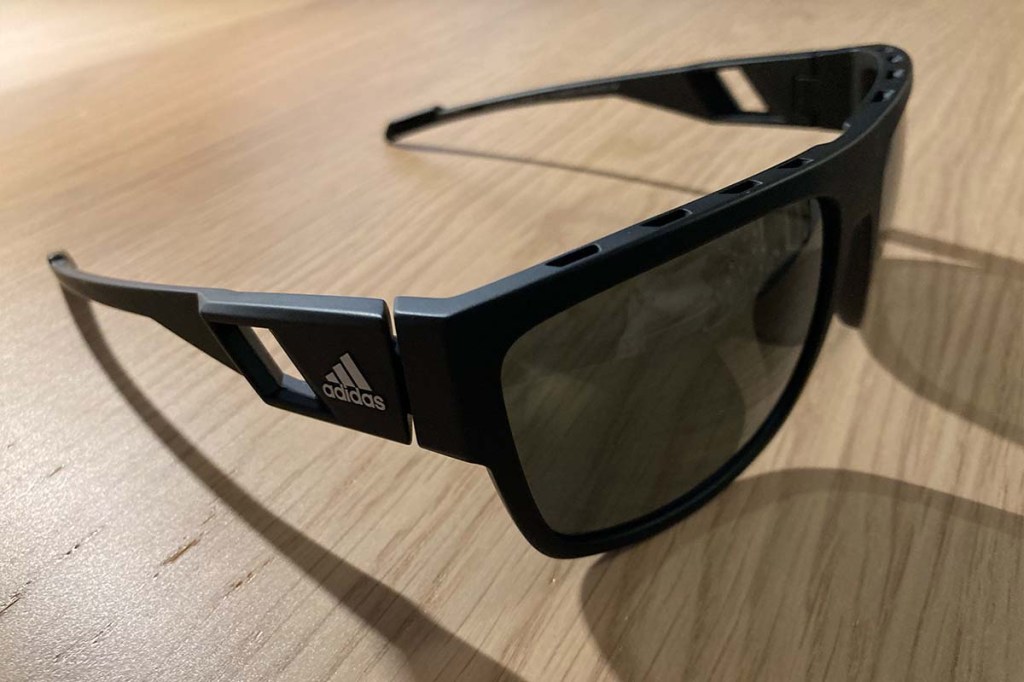 Schwarze Sonnenbrille von der Seite auf einem Tisch liegend