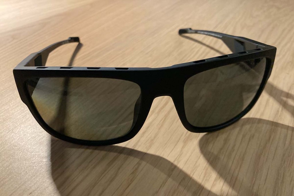 Schwarze Sonnenbrille von vorne auf einem Tisch liegend